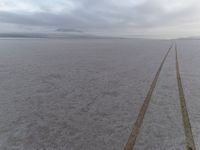 an empty road leads to the horizon in the winter time at an expansive plain near the coast