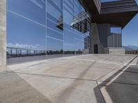 this is an outdoor patio with a glass fence next to the building and some benches