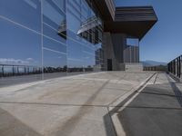 this is an outdoor patio with a glass fence next to the building and some benches