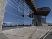 this is an outdoor patio with a glass fence next to the building and some benches