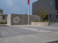 a building with a logo painted on the side near a street that has a sidewalk next to it