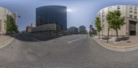 this panorama is a reflection of a traffic light and buildings on a city street near some trees