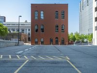 a street with a building near the building in the middle and on the left of which is a parking lot, as shown in this photo