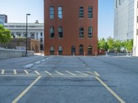 a street with a building near the building in the middle and on the left of which is a parking lot, as shown in this photo