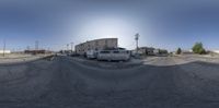 a bus and other trucks on a road near some buildings in the background from an upside down fisheye lens