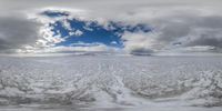 this is a picture looking down on the ocean with snow on the ground and cloudy skies above