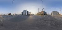 a view of two buildings on the side of a road from a fish eye lens