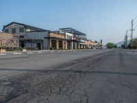 the empty street outside of the business district is empty and deserted with vehicles parked in it