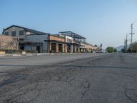 the empty street outside of the business district is empty and deserted with vehicles parked in it