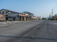 the empty street outside of the business district is empty and deserted with vehicles parked in it