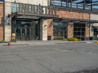 the empty street outside of the business district is empty and deserted with vehicles parked in it