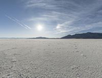 a big empty desert field with some tracks in it for the camera and sky in the background