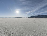 a big empty desert field with some tracks in it for the camera and sky in the background