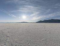 a big empty desert field with some tracks in it for the camera and sky in the background