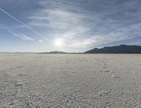 a big empty desert field with some tracks in it for the camera and sky in the background
