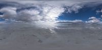 a view from a mirror on the sky of a large snow covered area of a mountain