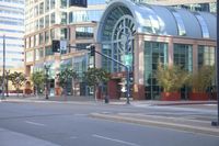 a city street has an empty parking lot and a green traffic light with some cars on the side