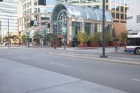 a city street has an empty parking lot and a green traffic light with some cars on the side
