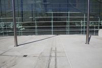 a metal pole in front of some windows on top of a sidewalk in front of some buildings