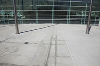 a metal pole in front of some windows on top of a sidewalk in front of some buildings