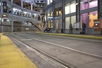 two street cars sitting on the side of a train track in front of some people walking