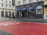 the stoplight near the store is red painted on the street road next to the sign for the shop