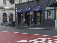 the stoplight near the store is red painted on the street road next to the sign for the shop