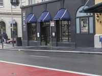 the stoplight near the store is red painted on the street road next to the sign for the shop