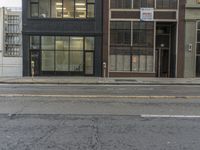 a parking meter sitting in the middle of a street next to a tall building with windows