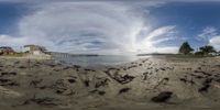 a panorama shot of the beach with sand and buildings near it on a clear day