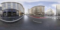 a fish - eye lens view of a city street, the same street for which there are many buildings