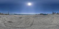 a photograph taken in an angle perspective of a beach area and a bridge that is very large