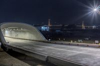 an empty tunnel is illuminated by street lights at night in a city park - like setting