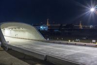 an empty tunnel is illuminated by street lights at night in a city park - like setting