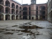 an empty courtyard with lots of arches and columns in it's center, and another building inside with a large area at the side