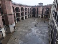 an empty courtyard with lots of arches and columns in it's center, and another building inside with a large area at the side