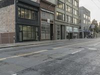 a picture of an empty street in front of a building and some wires and windows
