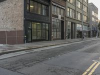 a picture of an empty street in front of a building and some wires and windows