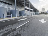 the empty street has long poles near it in front of the building of the building