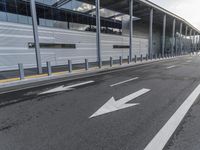 the empty street has long poles near it in front of the building of the building