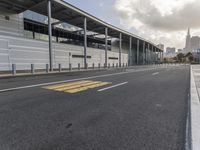 the empty street has long poles near it in front of the building of the building