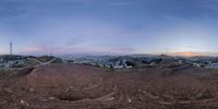 a panorama with a mountain and mountains in the background at sunset with some clouds above