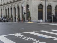 a white and red crosswalk on a street corner with a building in the background