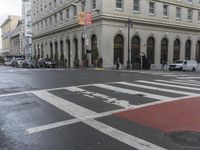 a white and red crosswalk on a street corner with a building in the background