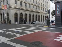 a white and red crosswalk on a street corner with a building in the background