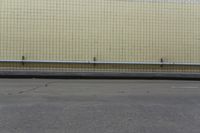 a wall next to a street with no people outside it or cars parked on the curb