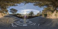 a street intersection is shown through the lens of this fish eye lens phone camera photograph