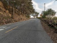 this is an image of a road with the sign on the side of it, with some trees at the end of the road