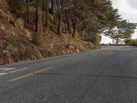 this is an image of a road with the sign on the side of it, with some trees at the end of the road