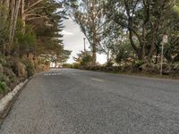 this is an image of a road with the sign on the side of it, with some trees at the end of the road